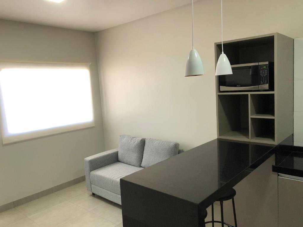 una cucina con bancone e sedia in una stanza di Vêneto Flat Residence (AP-02) a Primavera do Leste