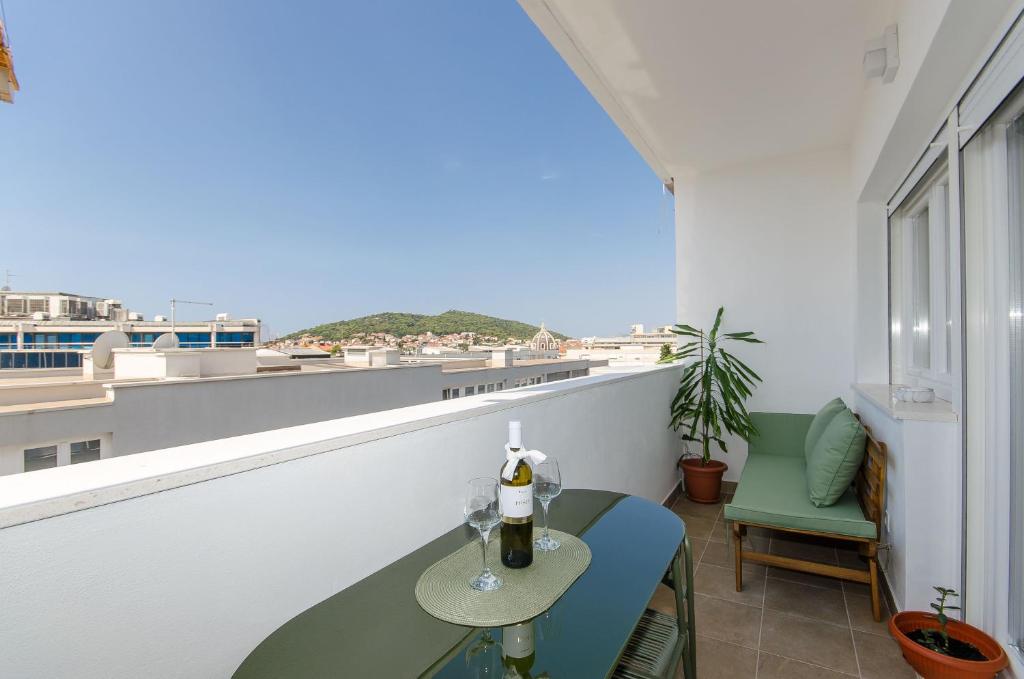 een balkon met een tafel en uitzicht op de oceaan bij Modern living apartment Airy in Split
