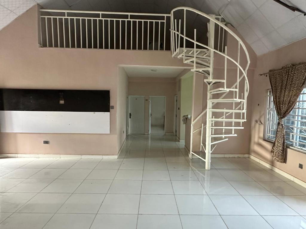 escalera de caracol en una habitación con pasillo en Kams Lodge Broadview, Idu, en Furah