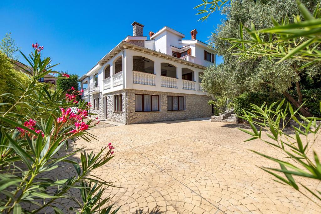 ein großes Haus mit einer Ziegelsteinfahrt in der Unterkunft Villa The Nest in Opatija