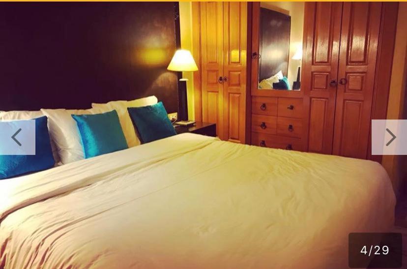 - une chambre avec un grand lit blanc et des oreillers bleus dans l'établissement palmeraie village 2, à Marrakech