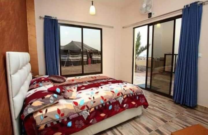 Bait Alaqaba dive center & resort في العقبة: غرفة نوم بسرير ونافذة كبيرة