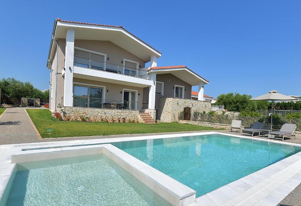 una casa con piscina frente a una casa en Cocoon Elegant Living, en Gerakini