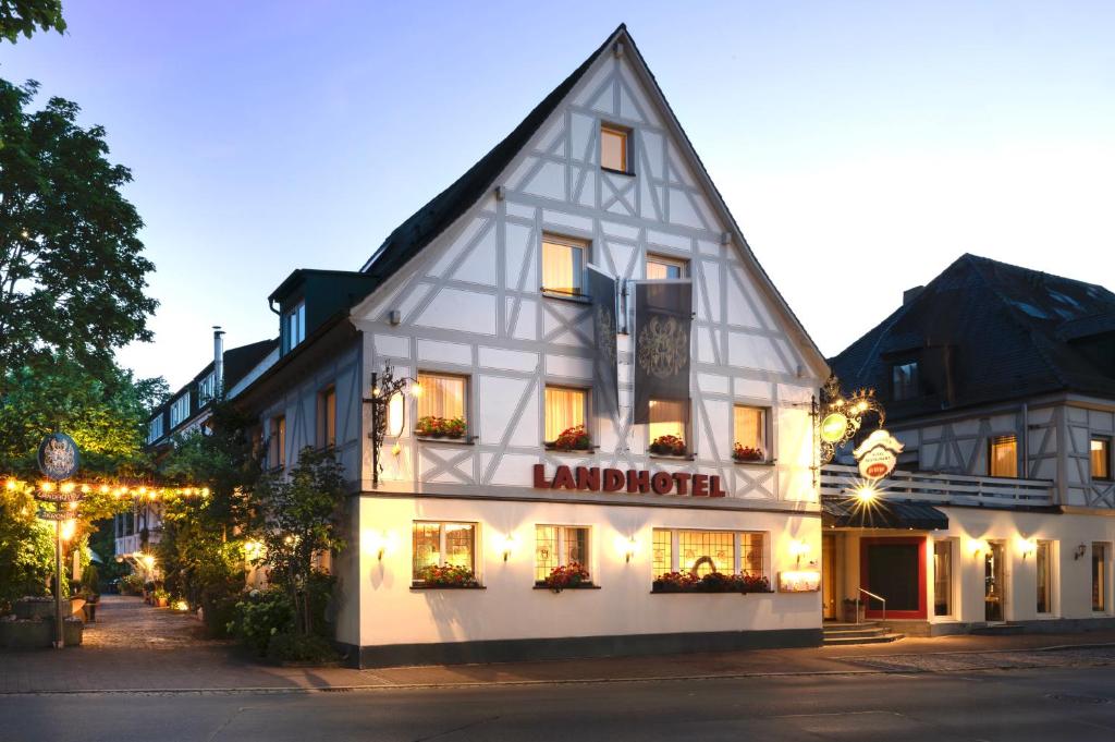 um grande edifício branco com um cartaz em Landhotel 3Kronen em Adelsdorf