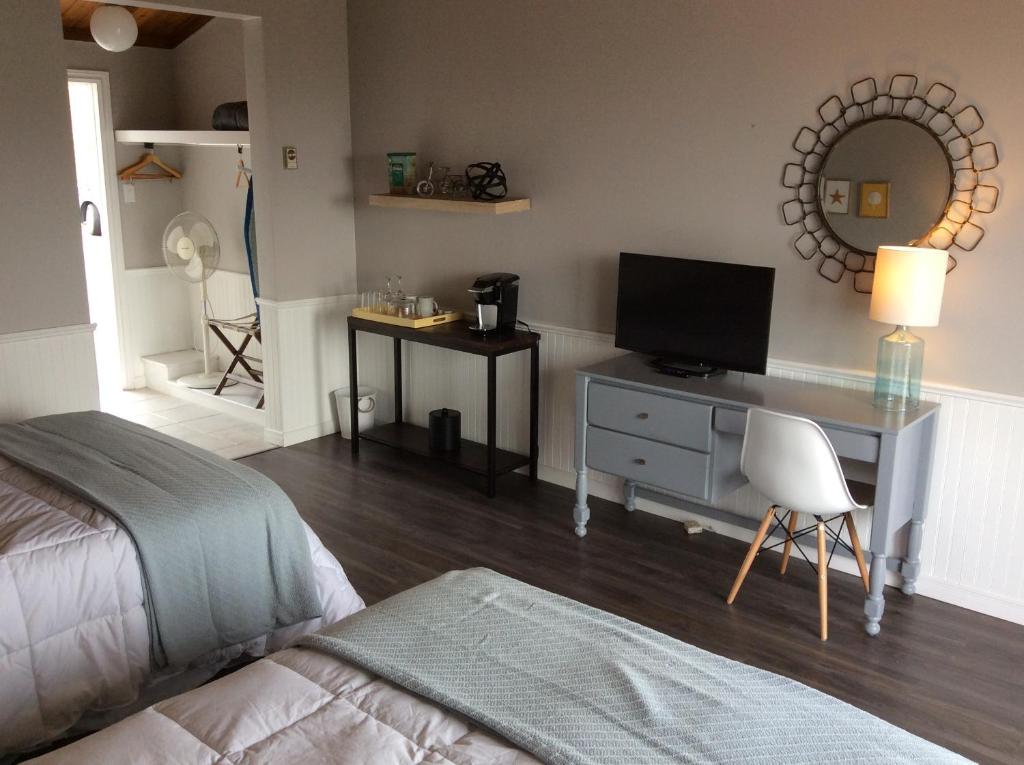 a bedroom with a bed and a desk with a television at The Iona Heights Inn in Iona