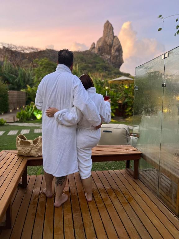 a man and a woman standing in front of a window at Dolphin Hotel in Fernando de Noronha