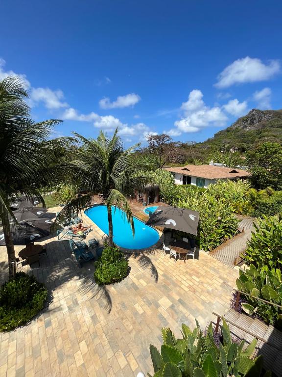 a patio with a blue pool and palm trees at Dolphin Hotel in Fernando de Noronha
