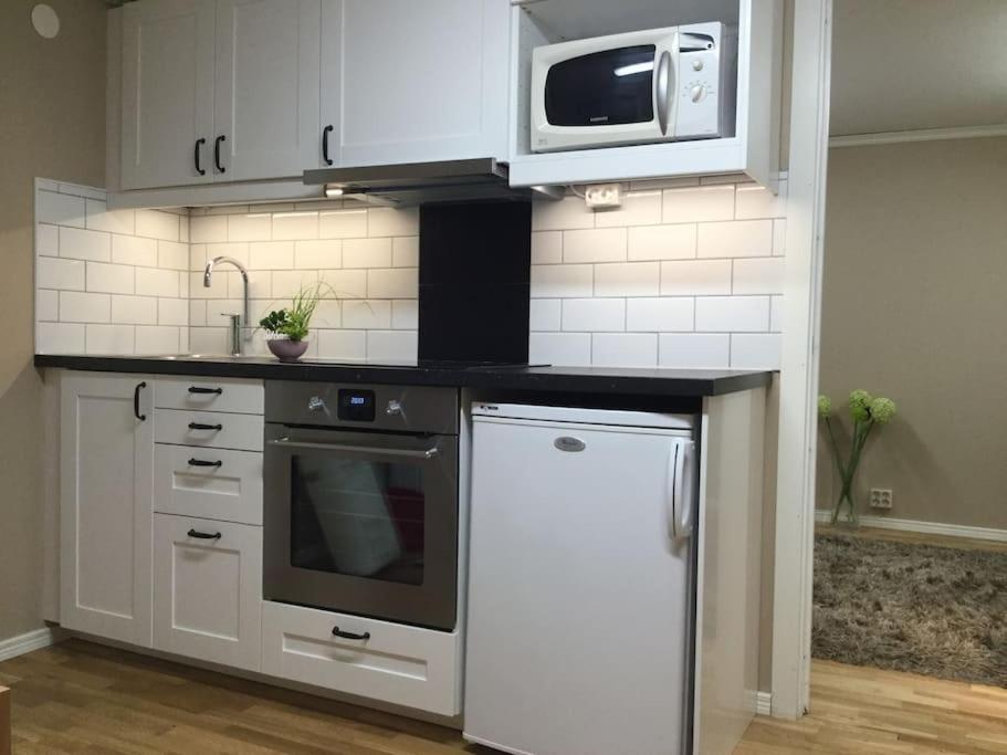 una cucina con elettrodomestici bianchi e forno a microonde di Egen lägenhet i charmig miljö i Linköping V a Vikingstad