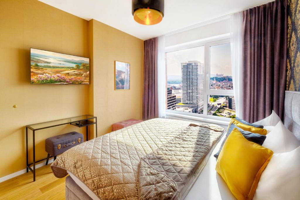 una camera d'albergo con un letto e una grande finestra di KLINGER Downtown Central City High Floor a Bratislava