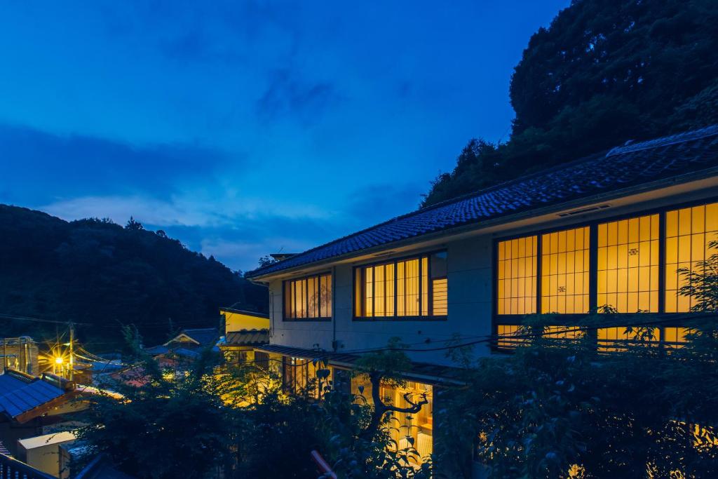 una casa por la noche con las luces encendidas en Showcase Hotel KASANE, en Gotsu