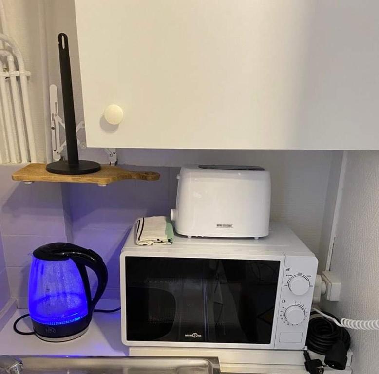 a microwave sitting on top of a counter with a blender at Résidence Bellevue in Wimereux