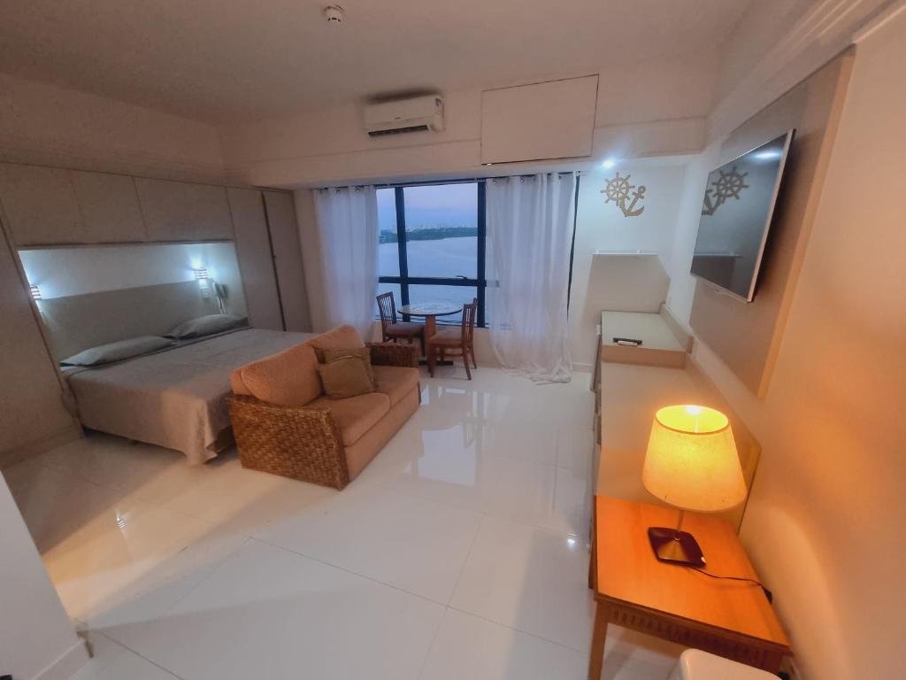 マナウスにあるTropical Executive Vista Ponta Negraのベッドルーム1室(ベッド1台、ソファ、テーブル付)
