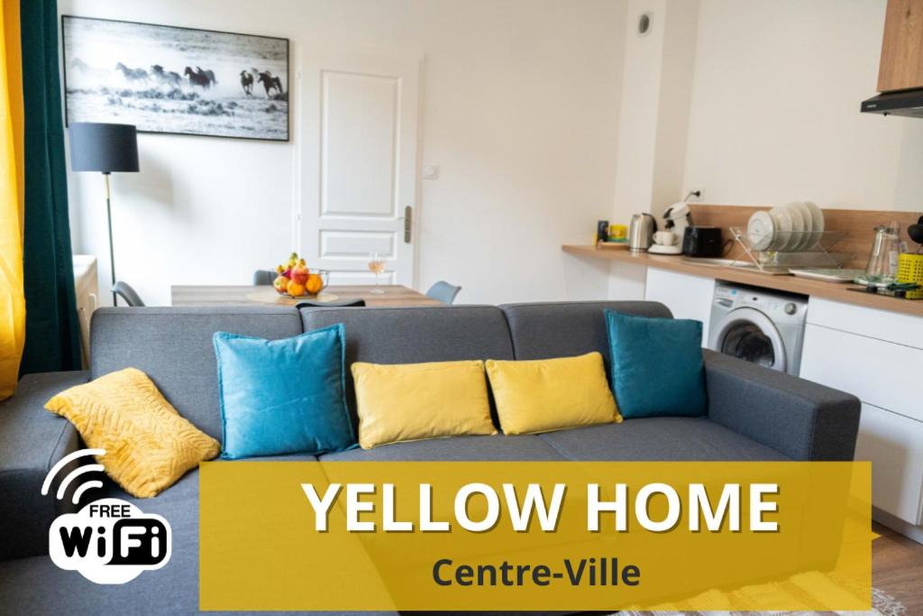 sala de estar con sofá gris y almohadas amarillas y azules en YELLOW HOME, en Fougères