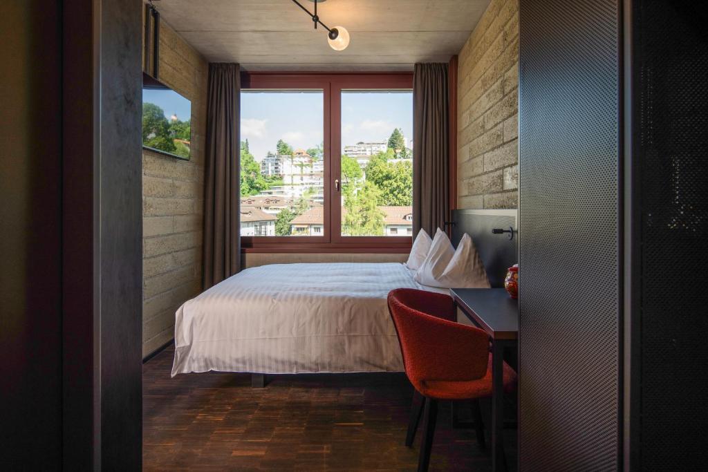 Postel nebo postele na pokoji v ubytování Tailormade Hotel LEO St Gallen