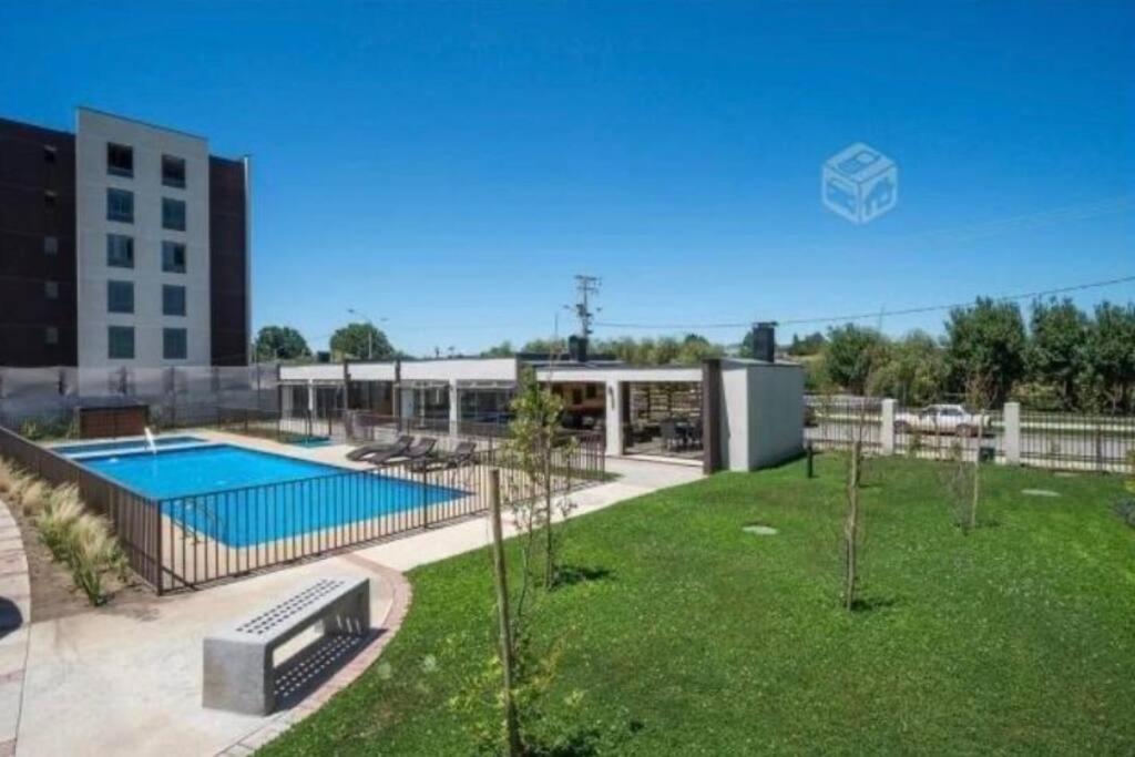 a large yard with a swimming pool and a building at Acogedor y cómodo depto. 2d+2b in Los Ángeles