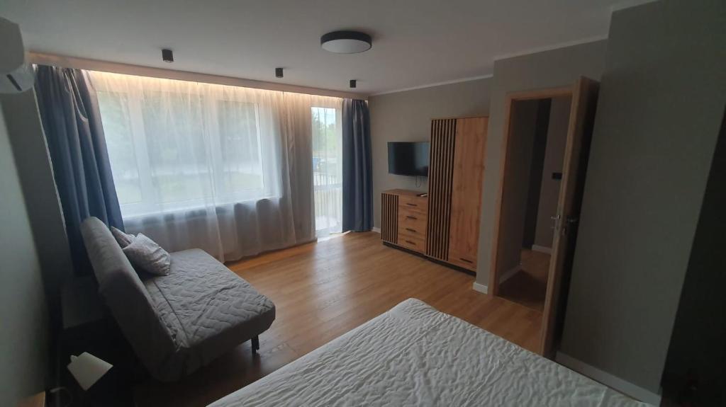 ein Wohnzimmer mit einem Sofa und einem Stuhl in der Unterkunft Słoneczny apartament in Augustów