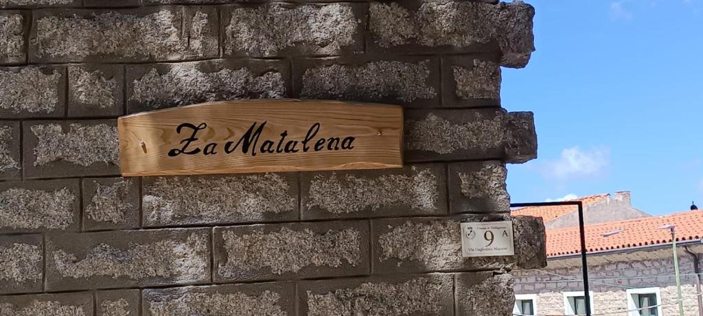 een bord aan de zijkant van een stenen muur bij Za Matalena in Calangianus