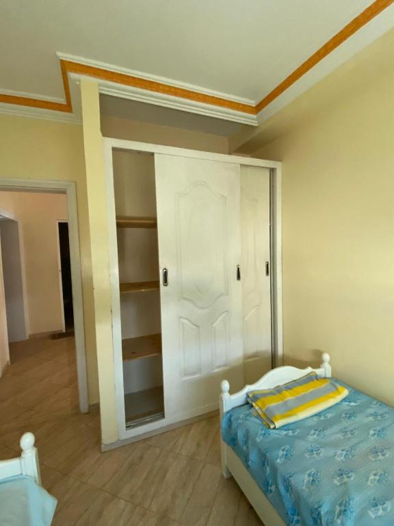 um quarto com uma cama e um closet em APARTAMENTO moulay boslham em Kenitra