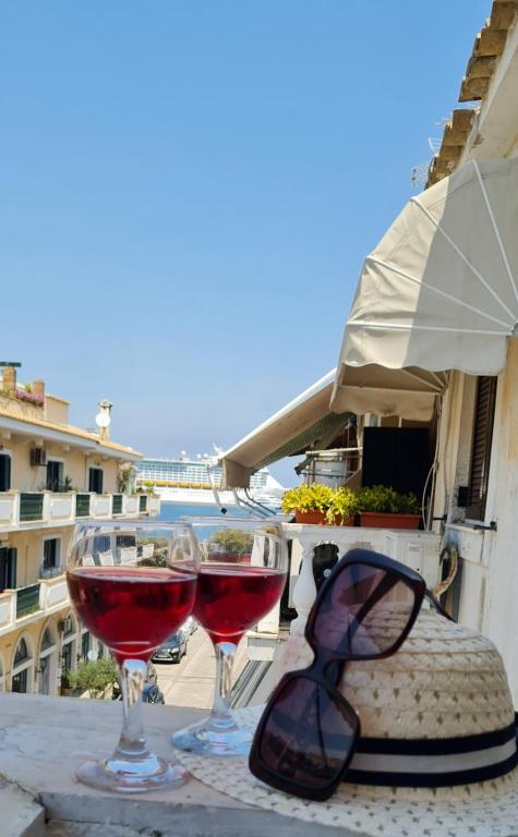 two glasses of red wine sitting on a table at Dimitra House Madouki Corfu in Mantoúkion