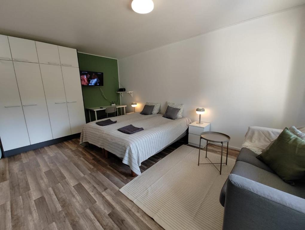 een slaapkamer met een bed en een bank bij New studio near amenities in Nilsiä