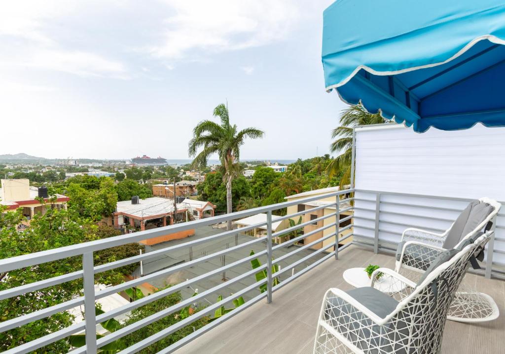 a balcony with two chairs and an umbrella at MB Apartment - A in San Felipe de Puerto Plata