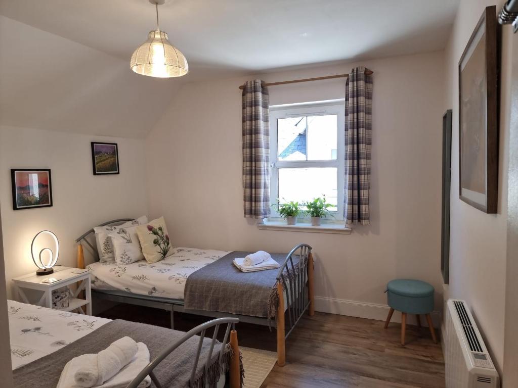 インバネスにあるHeart of Inverness-city apartmentのベッドと窓が備わる小さな客室です。
