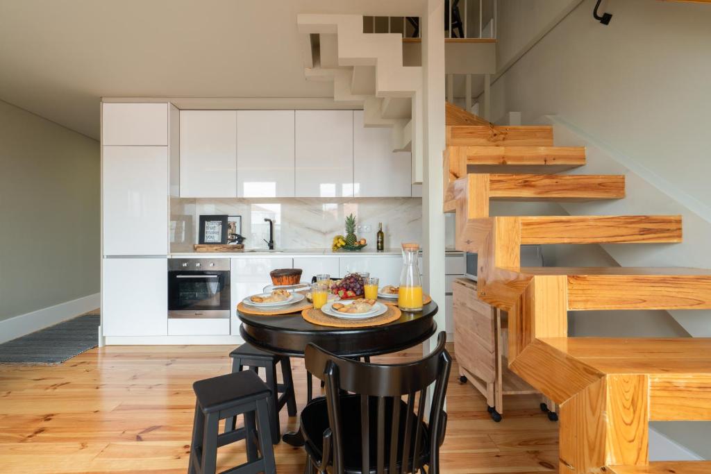 een keuken met een tafel en stoelen en een trap bij Modern Design Duplex w/ Balcony in Porto
