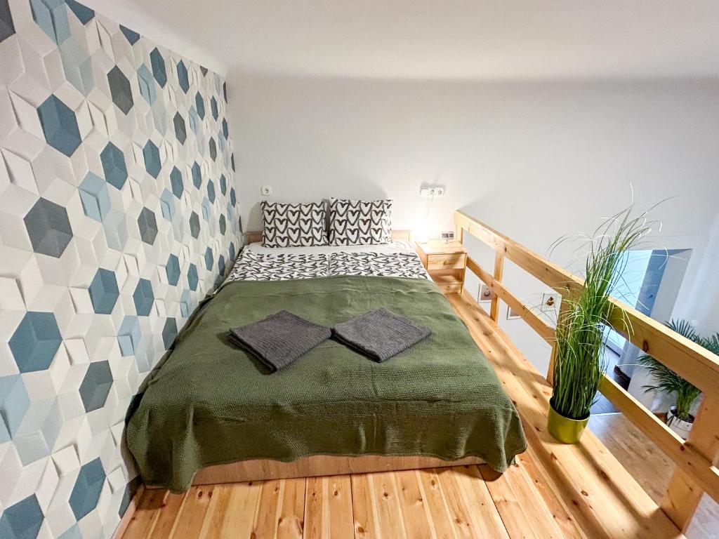 1 dormitorio con 1 cama con manta verde en Colorful apartment next to Gozsdu and Synagogue, en Budapest