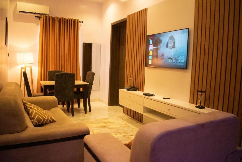 - un salon avec un canapé et une télévision murale dans l'établissement Sapphire Residences by Crystal, à Ikeja