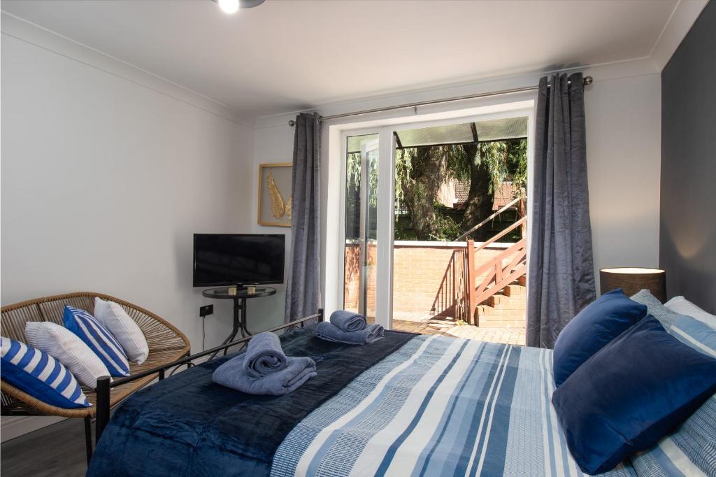 um quarto com uma cama e uma porta de vidro deslizante em No5a, Studio Apartment, Willowbrook House em Bedworth