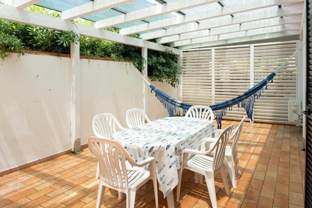 een tafel en stoelen op een patio met een hangmat bij vacanze a tremiti in San Domino