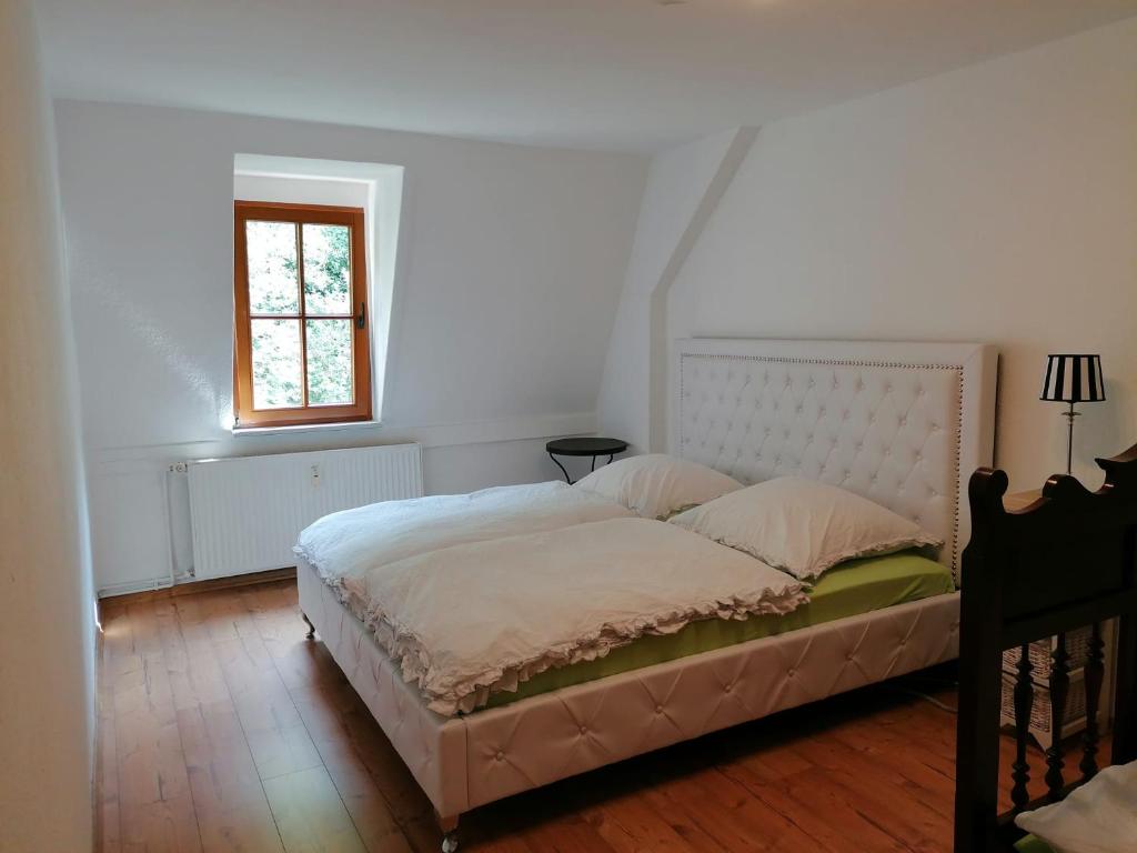 Schlafzimmer mit einem großen Bett und einem Fenster in der Unterkunft Bergblick in Königstein an der Elbe