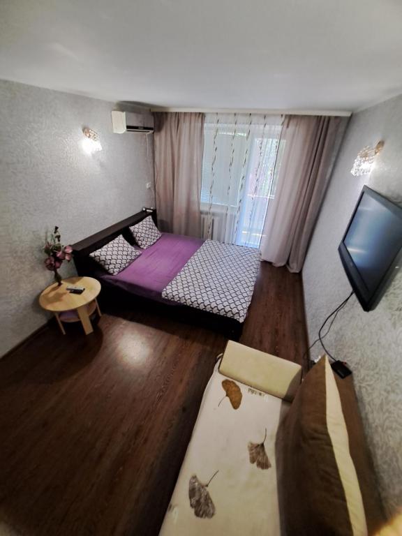 een kleine kamer met een bed en een televisie bij однокомнатная квартира в сердце города in Krivoy Rog