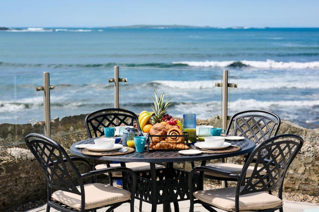 a table with a bowl of fruit on the beach at Armada Cottages in Spanish Point