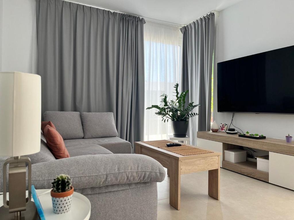 a living room with a couch and a flat screen tv at Casa el Timple in Costa Teguise