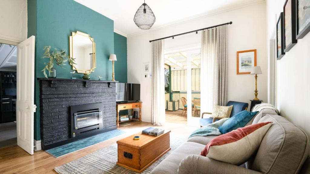 a living room with a couch and a fireplace at Casa Merenda Daylesford in Daylesford
