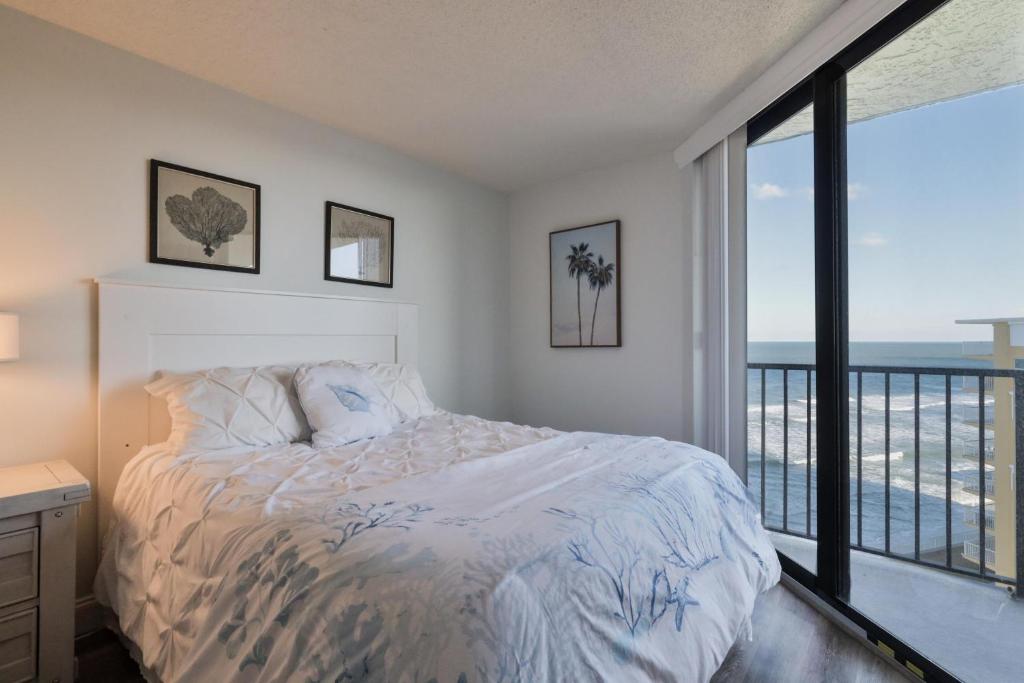 a bedroom with a bed with a view of the ocean at 1 Bedroom -1 Bath Ocean View Condo At Ocean Trillium 802 in New Smyrna Beach