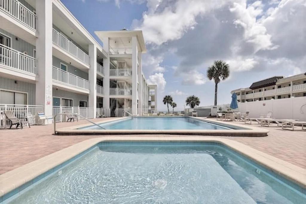 a swimming pool in front of a building at Coastal Waters 210 - 2nd Floor 1 Bedroom With 2 Queen Beds in New Smyrna Beach