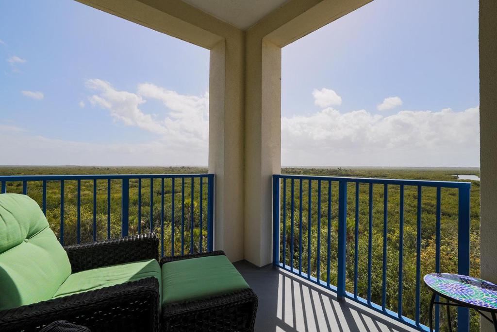 a balcony with a chair and a view of the ocean at 3 Bedroom 2 Bath Oceanwalk Condo With Estuary Views in New Smyrna Beach