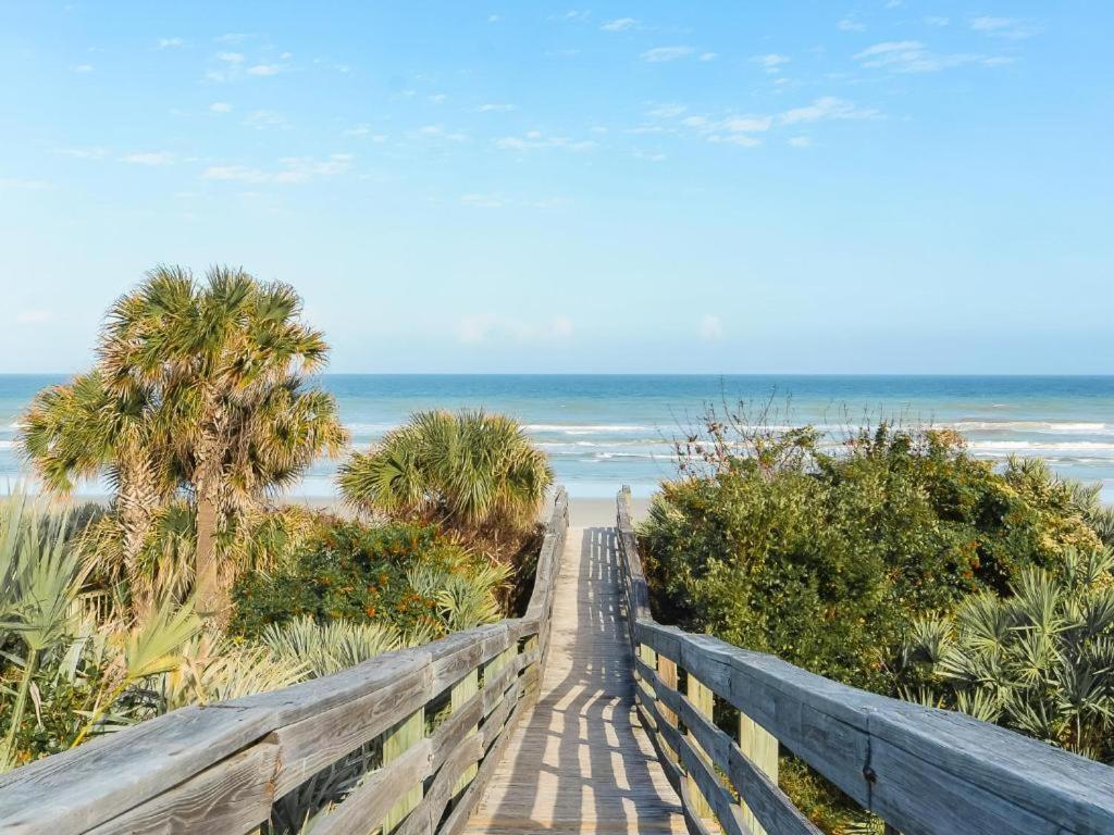a boardwalk to the beach with the ocean in the background at Sea Woods Large 1 Bedroom Condo And A Whole Lot Of Amenities! in New Smyrna Beach