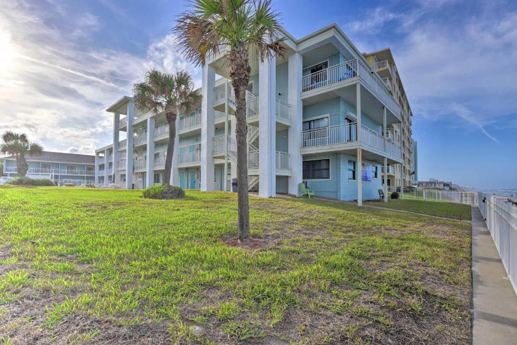 a large building with palm trees in front of it at Coastal Waters 108-109- 2 Bedroom 2 Bath Pool Side Condo! in New Smyrna Beach