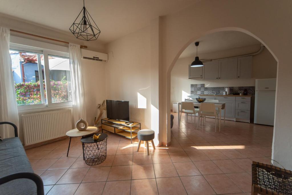 a living room with an archway and a kitchen with a table at Castle's Soul in Kavála