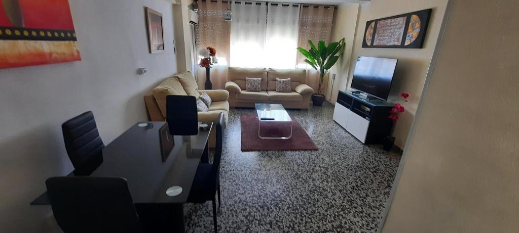 sala de estar con sofá y TV en Apartamento Jose Maria Corona, en Málaga