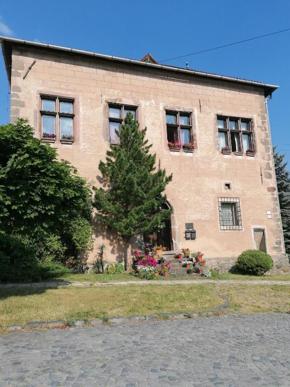a brick building with a tree in front of it at Gothic House Apartments in Kremnica