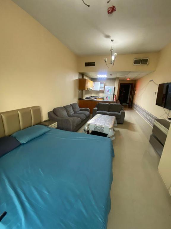 1 dormitorio con 1 cama grande y sala de estar en استديو مفروش بتاور سي عجمان شامل جميع الفواتير للايجار الشهري, en Ajman