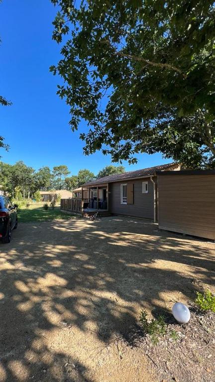 une maison avec une voiture garée devant dans l'établissement Chalet la landaise en bord du lac de Peyre à Labouheyre, à Labouheyre