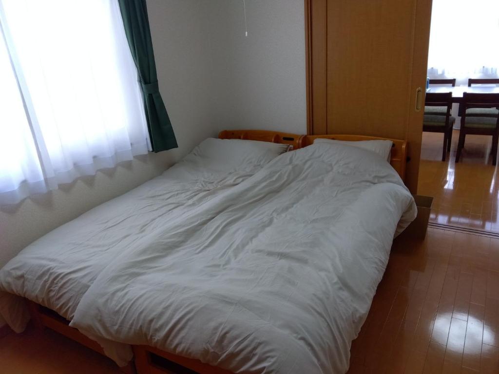 a large white bed in a room with a window at Restful Tsukuda - Vacation STAY 14829 in Aomori