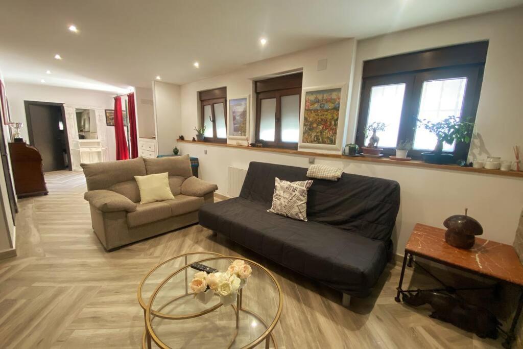 ein Wohnzimmer mit einem Sofa und einem Tisch in der Unterkunft Apto. entero. Nuevo y muy cómodo in El Escorial