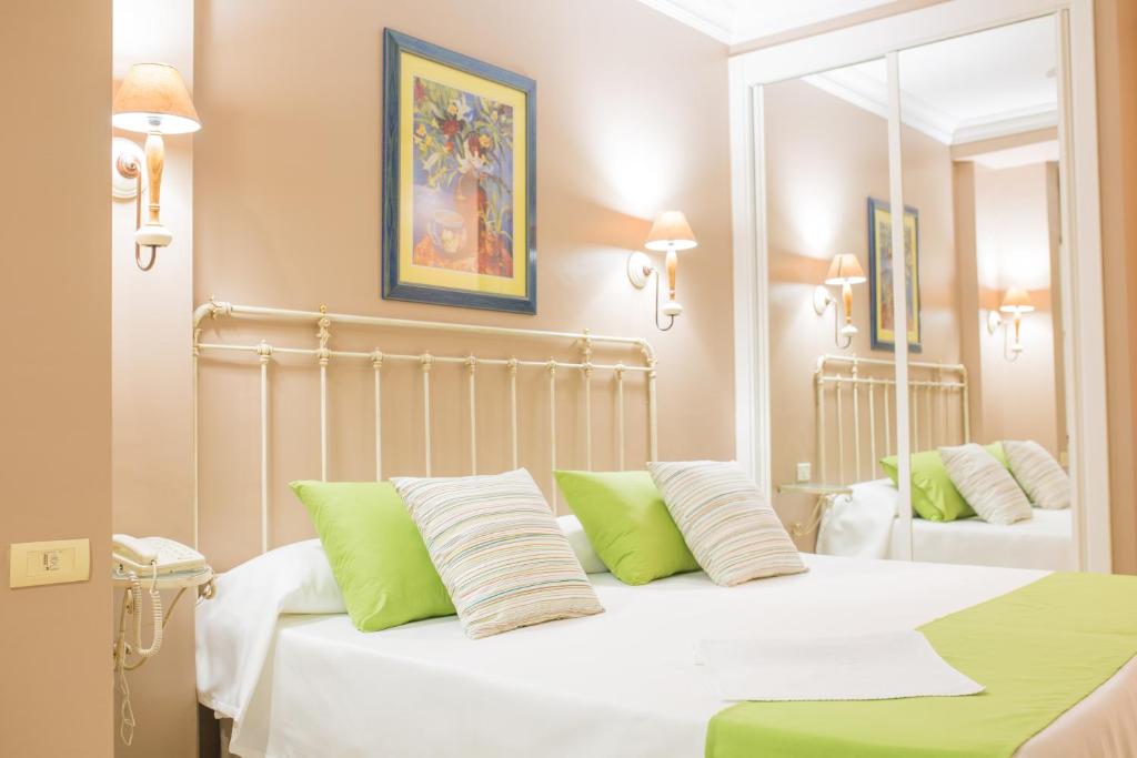 Un dormitorio con una cama blanca con almohadas verdes y blancas en Hotel RF Astoria - Adults Only, en Puerto de la Cruz