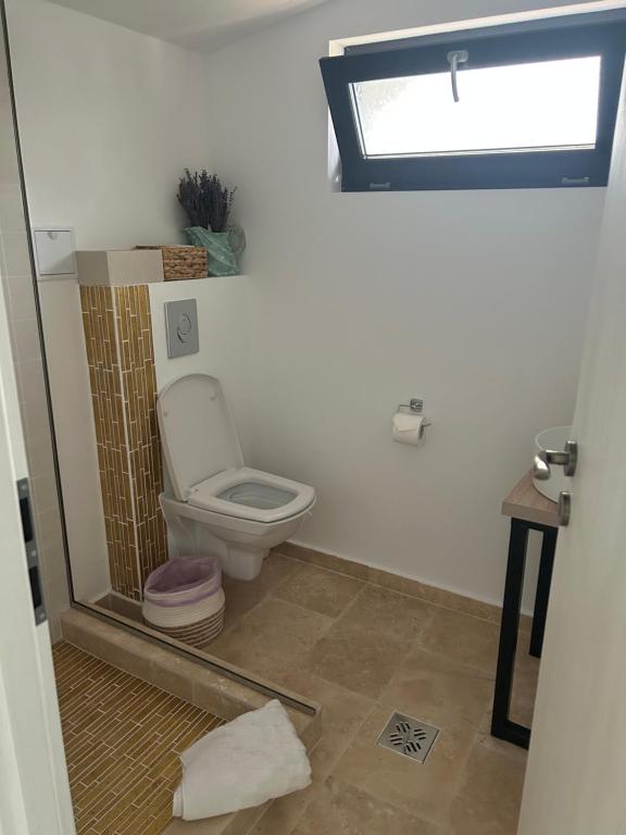 uma casa de banho com um WC e uma janela em Saga em Mangalia